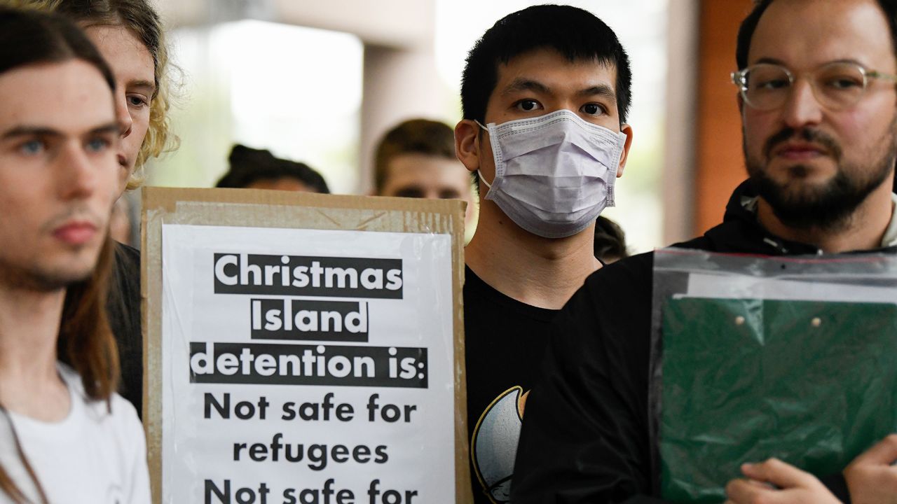 Protesters hold placards during a rally against an inbound travel ban on foreign travellers from China in Sydney on February 7, 2020. 