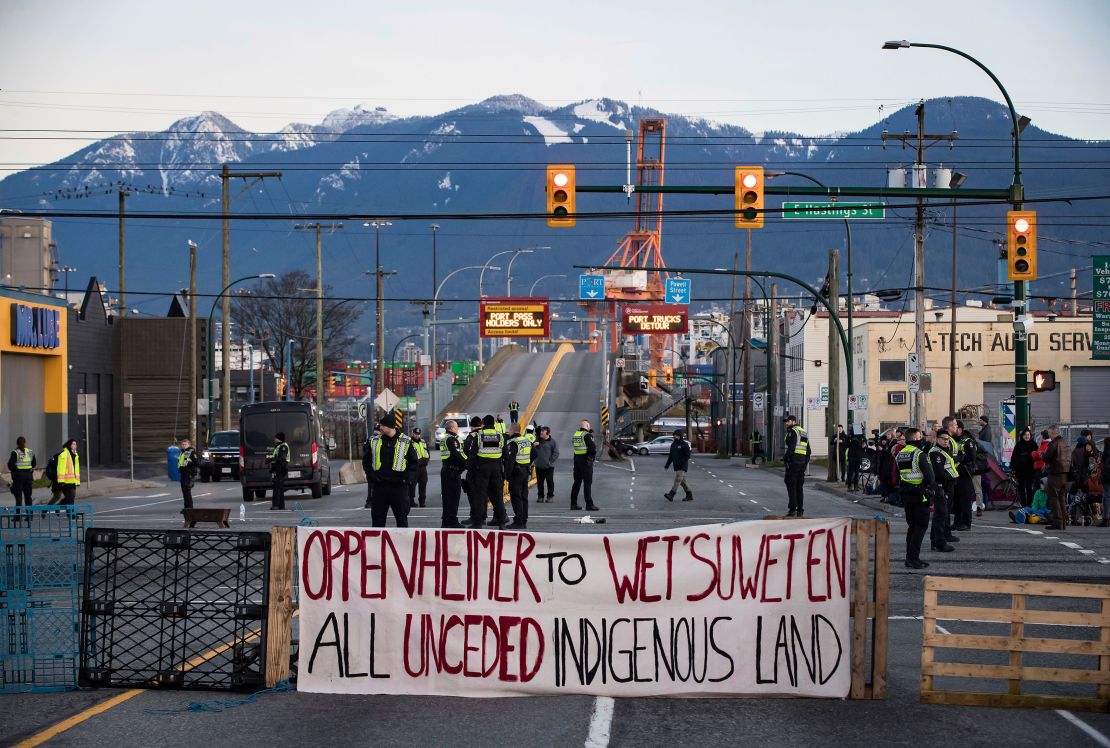 Police officers stand on a road after clearing the intersection of protesters that were blocking an entrance to a port Wednesday in Vancouver, British Columbia. The demonstration expressed solidarity with Wet'suwet'en protesters who were arrested last week.