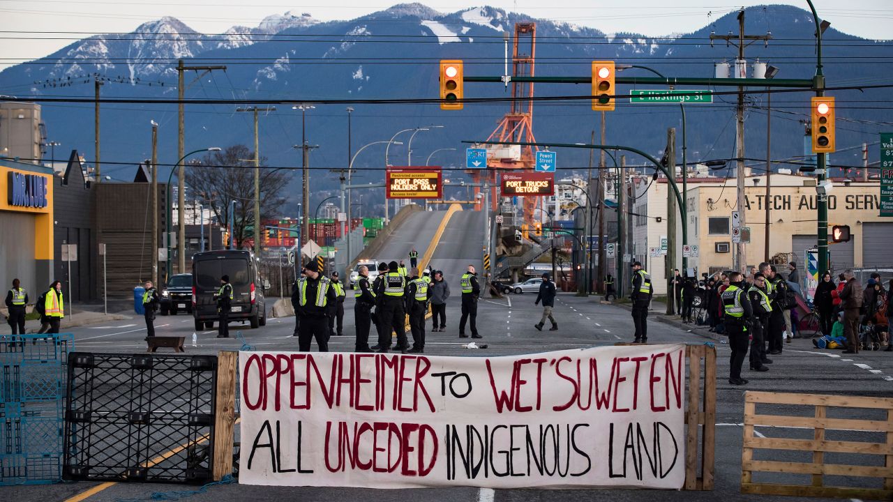 Police officers stand on a road after clearing the intersection of protesters that were blocking an entrance to a port Wednesday in Vancouver, British Columbia. The demonstration expressed solidarity with Wet'suwet'en protesters who were arrested last week.