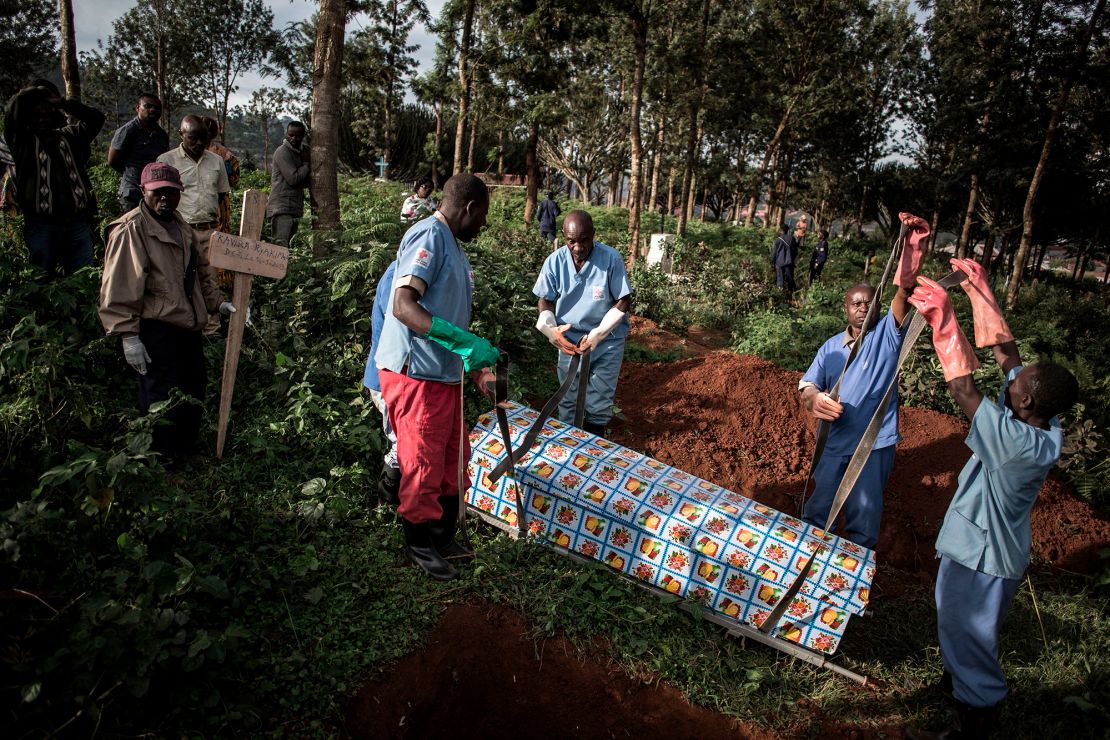 Health workers prepare to bury a coffin containing the body of an Ebola victim on May 16, 2019 in Butembo, DRC. 