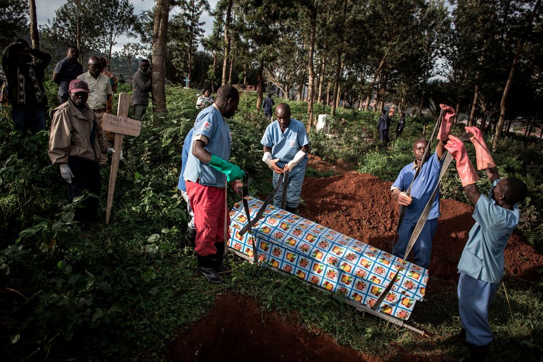 Health workers prepare to bury a coffin containing a victim of the ebola virus on May 16, 2019 in Butembo. 