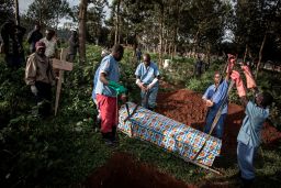 Health workers prepare to bury a coffin containing the body of an Ebola victim on May 16, 2019 in Butembo, DRC.