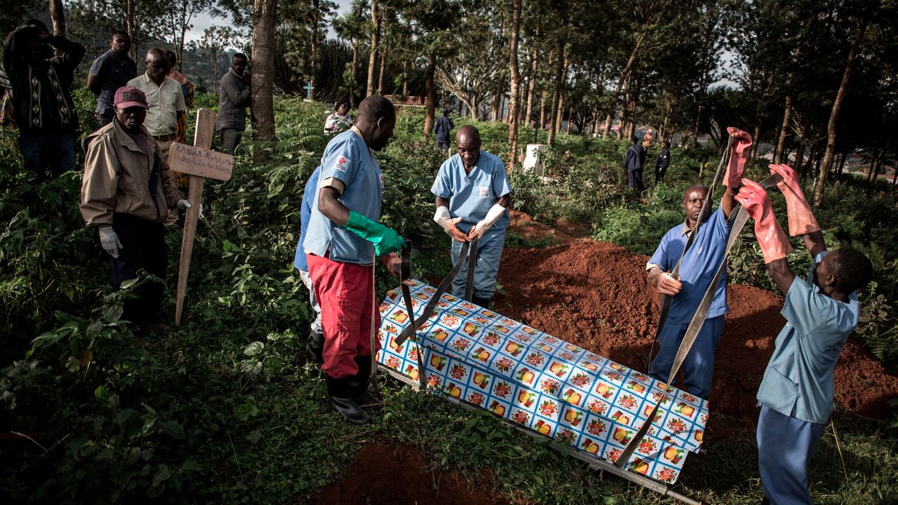 Health workers prepare to bury a coffin containing a victim of the ebola virus on May 16, 2019 in Butembo. 