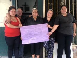 Nitzi Gonzalez and her family hold up purple tissue paper in support of victims of femicide.