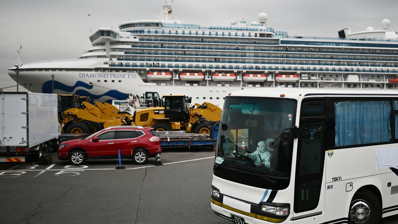 A bus with a driver wearing full protective gear departs from the dockside next to the Diamond Princess cruise ship, which has around 3,600 people quarantined onboard due to fears of the new COVID-19 coronavirus, at the Daikoku Pier Cruise Terminal in Yokohama port on February 14, 2020. - Japanese authorities were preparing Febraury 14 to move some older passengers who tested negative for the new coronavirus off a quarantined cruise ship and into government-designated lodging. (Photo by CHARLY TRIBALLEAU / AFP) (Photo by CHARLY TRIBALLEAU/AFP via Getty Images)