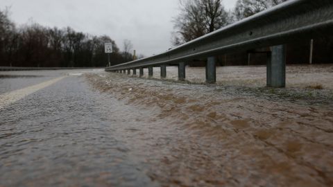Water from the swollen Pearl River pushes under the guardrail along Old Brandon Road Bridge in Jackson, Mississippi, on Sunday.