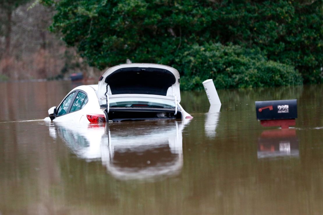 The open trunk of this vehicle is reflected in floodwaters from the Pearl River in northeast Jackson, Mississippi, on Sunday. 