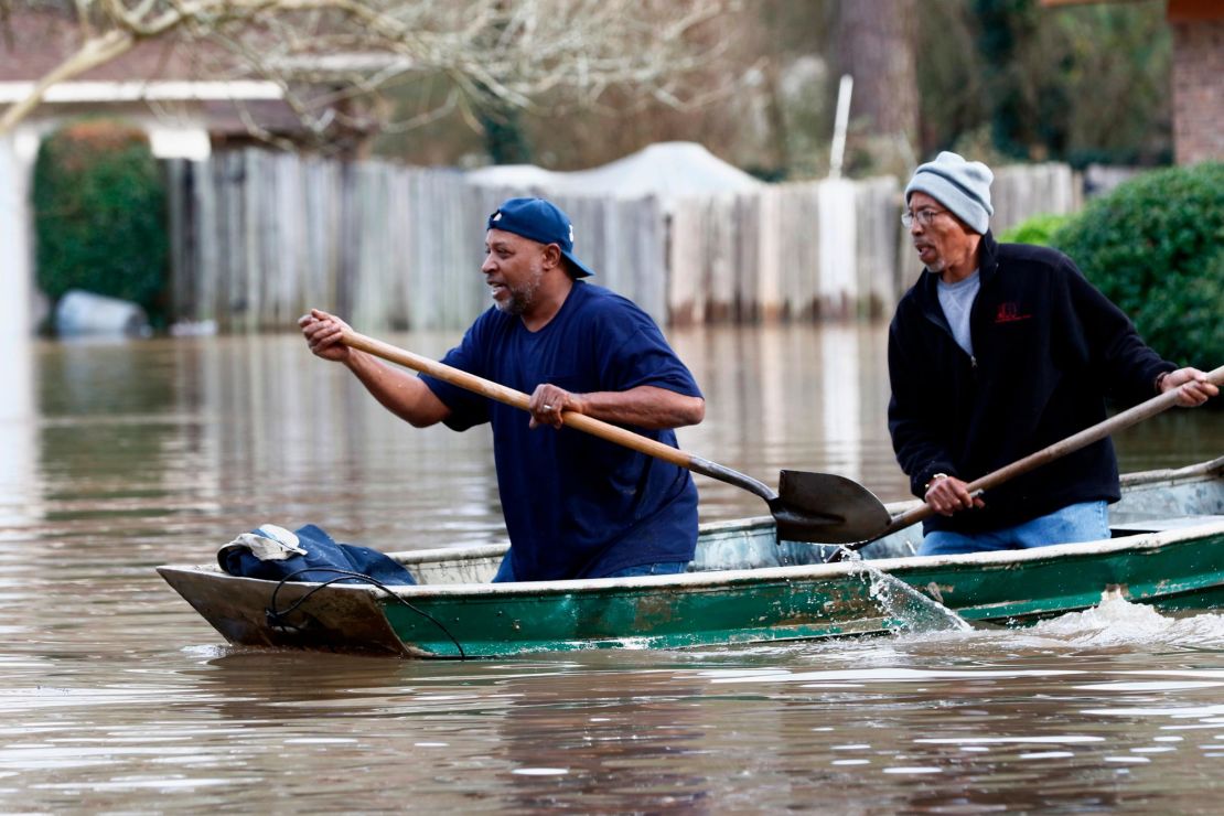 Homeowners in Jackson, Mississippi, use shovels to work their way through Pearl River floodwaters on Sunday.