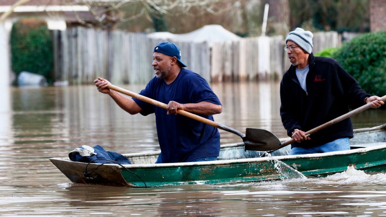 Homeowners in Jackson, Mississippi, use shovels to work their way through Pearl River floodwaters on Sunday.