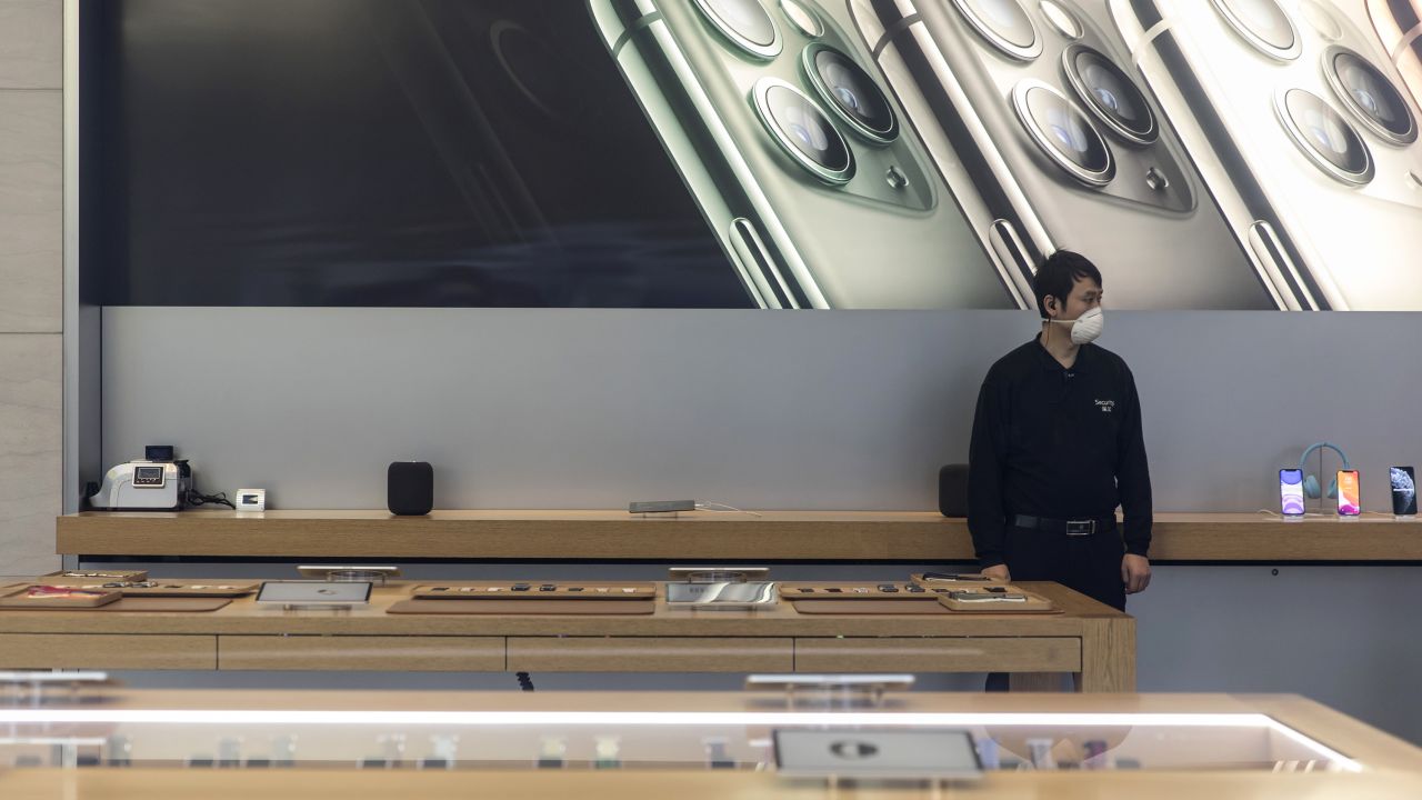 A security guard wearing a protective mask stands guard inside an Apple Inc. store in Shanghai, China, on Saturday, Feb. 15, 2020.