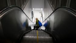 An elderly woman wearing a face mask rides an escalator at a subway station in Beijing on February 18, 2020. - The World Health Organization has warned against a global over-reaction to the new coronavirus epidemic following panic-buying, event cancellations and concerns about cruise ship travel, as China's official death toll neared 1,900 on February 18. (Photo by WANG ZHAO / AFP) (Photo by WANG ZHAO/AFP via Getty Images)