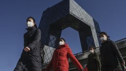 BEIJING, CHINA - FEBRUARY 17: Chinese women wear  protective masks as they pass the CCTV building on their way to work on February 17, 2020 in Beijing, China. The number of cases of the deadly new coronavirus COVID-19 rose to more than 57800 in mainland China Monday, in what the World Health Organization (WHO) has declared a global public health emergency. China continued to lock down the city of Wuhan in an effort to contain the spread of the pneumonia-like disease which medicals experts have confirmed can be passed from human to human. In an unprecedented move, Chinese authorities have maintained and in some cases tightened the travel restrictions on the city which is the epicentre of the virus and also in municipalities in other parts of the country affecting tens of millions of people. The number of those who have died from the virus in China climbed to over 1770 on Monday, mostly in Hubei province, and cases have been reported in other countries including the United States, Canada, Australia, Japan, South Korea, India, the United Kingdom, Germany, France and several others. The World Health Organization has warned all governments to be "on alert" and screening has been stepped up at airports around the world. Some countries, including the United States, have put restrictions on Chinese travellers entering and advised their citizens against travel to China. (Photo by Kevin Frayer/Getty Images)