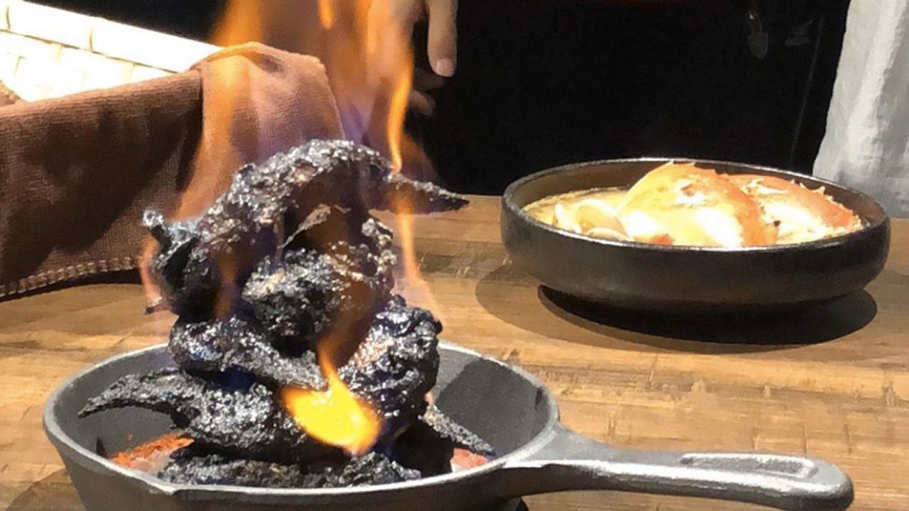 The bar's black fried chicken is set aflame, giving it a hellish appearance.