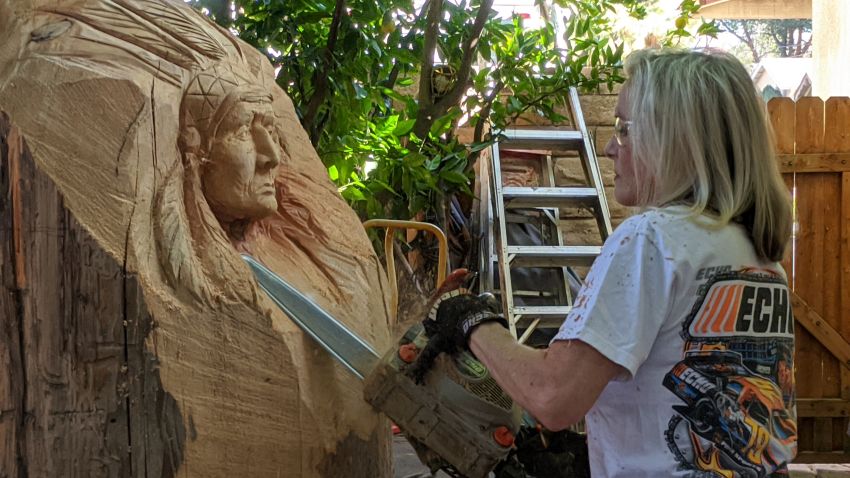 Cherie Currie of The Runaways uses a chainsaw to carve a cigar store indian