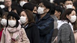  People wearing masks wait to cross a road  in the Shibuya district on February 02, 2020 in Tokyo, Japan