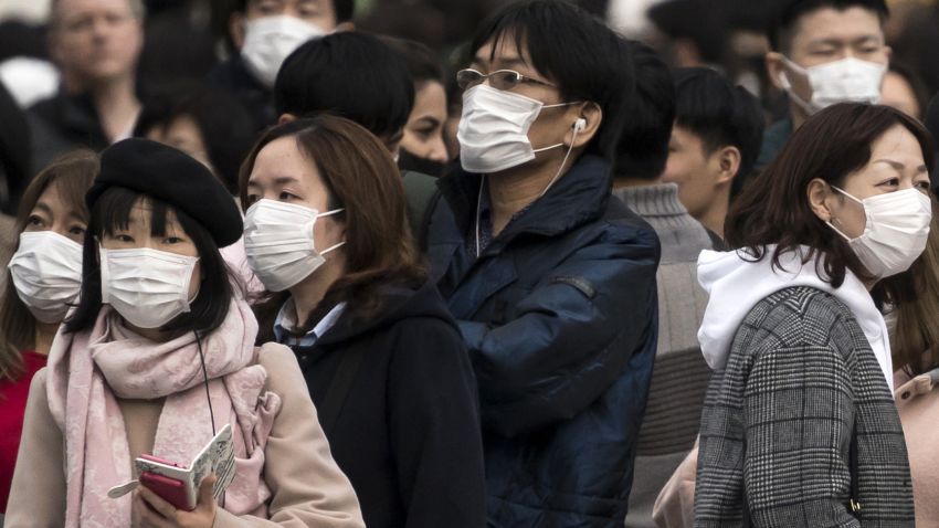 People wearing masks wait to cross a road  in the Shibuya district on February 02, 2020 in Tokyo, Japan
