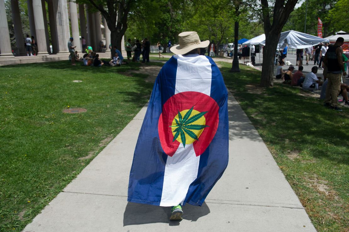 A man is draped in pro-marijuana colors during the Denver 420 Rally, the world's largest celebration of both the legalization of cannabis and cannabis culture, May 21, 2016 in Denver Coloroado. The western mountainous Colorado is one of four US states along with the District of Columbia that has legalized the use of recreational marijuana.       (Photo credit should read JASON CONNOLLY/AFP via Getty Images)