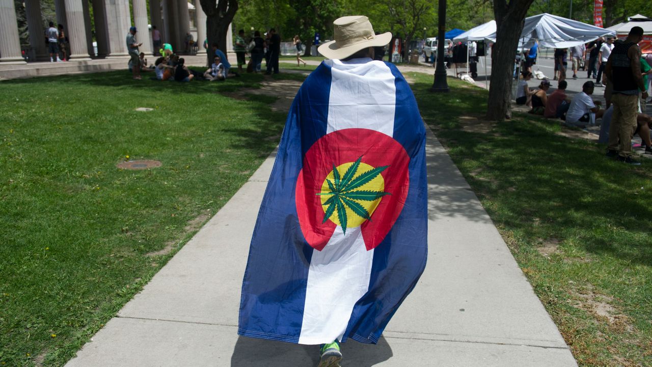A man is draped in pro-marijuana colors during the Denver 420 Rally, the world's largest celebration of both the legalization of cannabis and cannabis culture, May 21, 2016 in Denver Coloroado. The western mountainous Colorado is one of four US states along with the District of Columbia that has legalized the use of recreational marijuana.       (Photo credit should read JASON CONNOLLY/AFP via Getty Images)