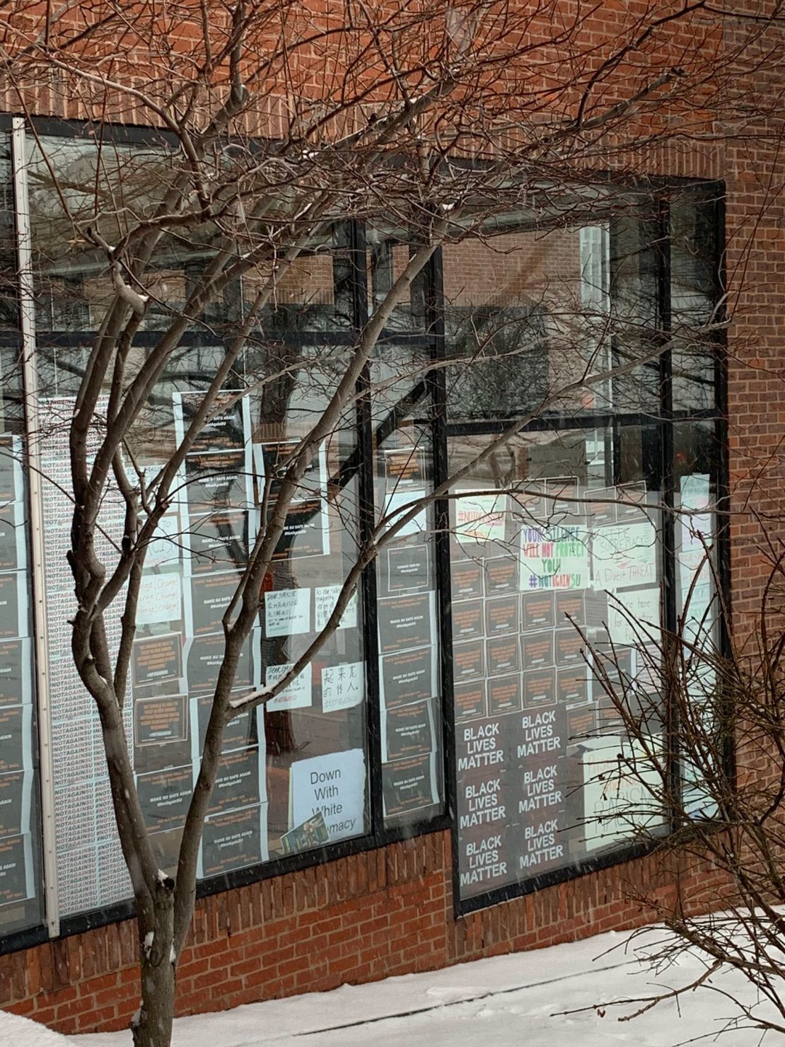 Students put up posters in Crouse-Hinds Hall protesting racist incidents on campus.