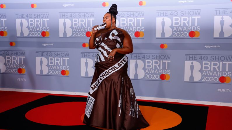 Lizzo takes a bite out of her clutch as she poses on the red carpet at the Brit Awards on Tuesday, February 18.
