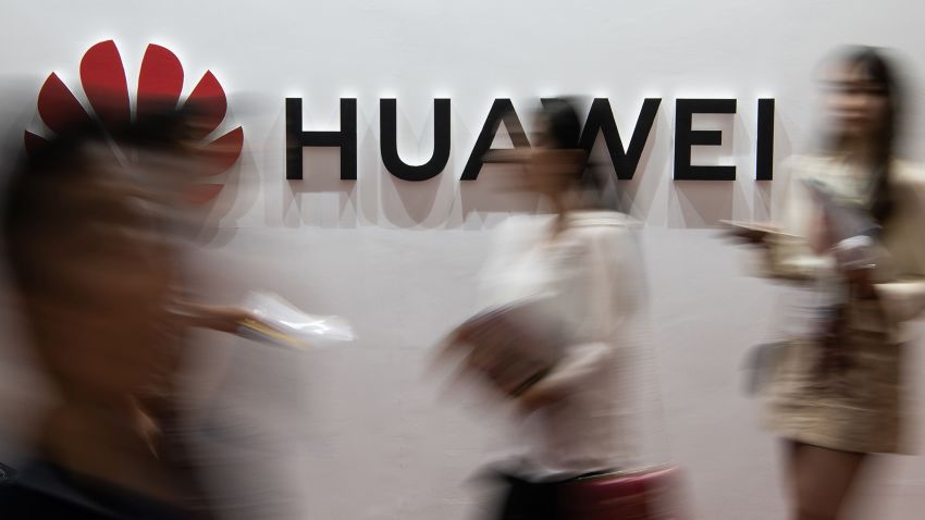 People walk past a Huawei logo during the Consumer Electronics Expo in Beijing on August 2, 2019. (Photo by Fred DUFOUR / AFP)        (Photo credit should read FRED DUFOUR/AFP via Getty Images)