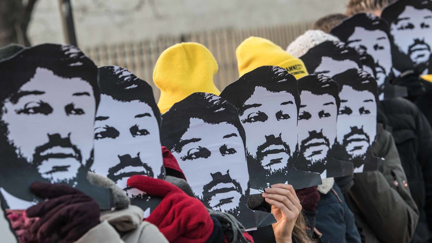 Amnesty International campaigners hold masks of Turkish rights activist Taner Kilic during a demonstration in Berlin in 2018. 