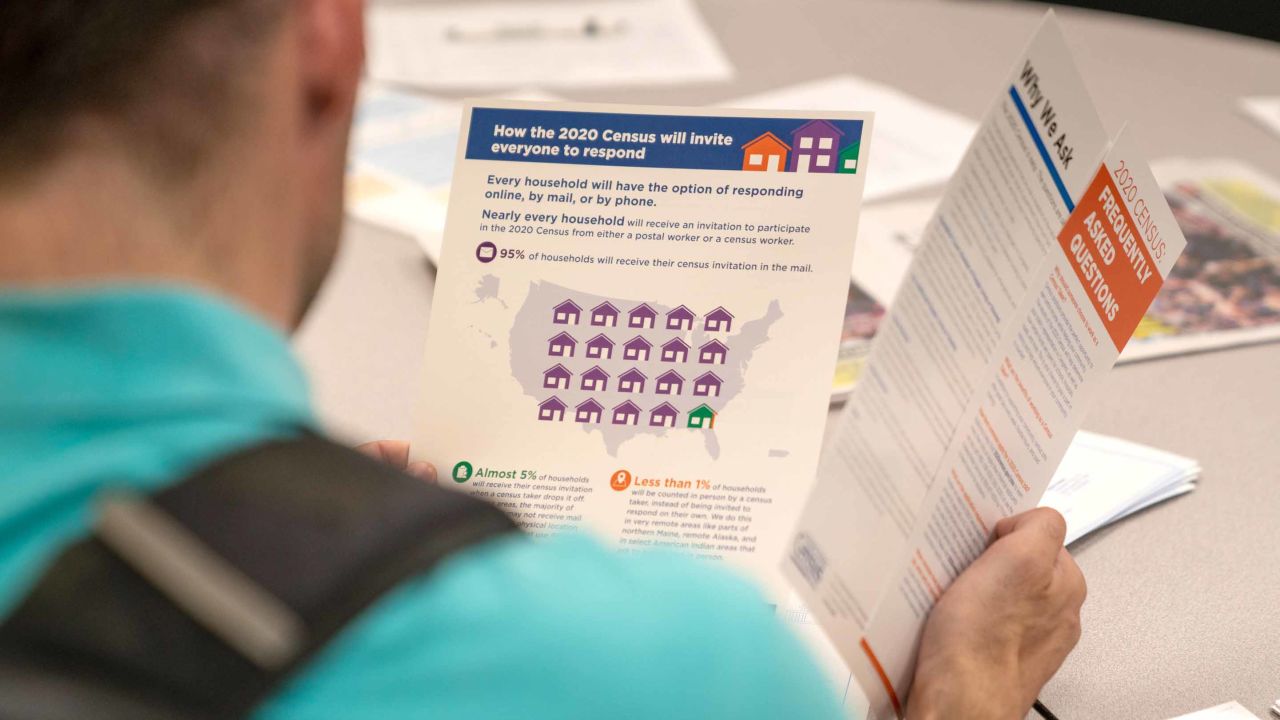 A man flips through an information packet during a Census Bureau job-opportunities workshop last July in New York.