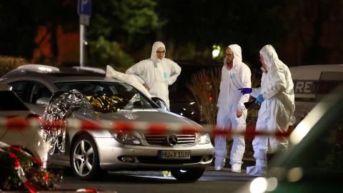 Forensic experts work around a damaged car after the attack in Hanau.