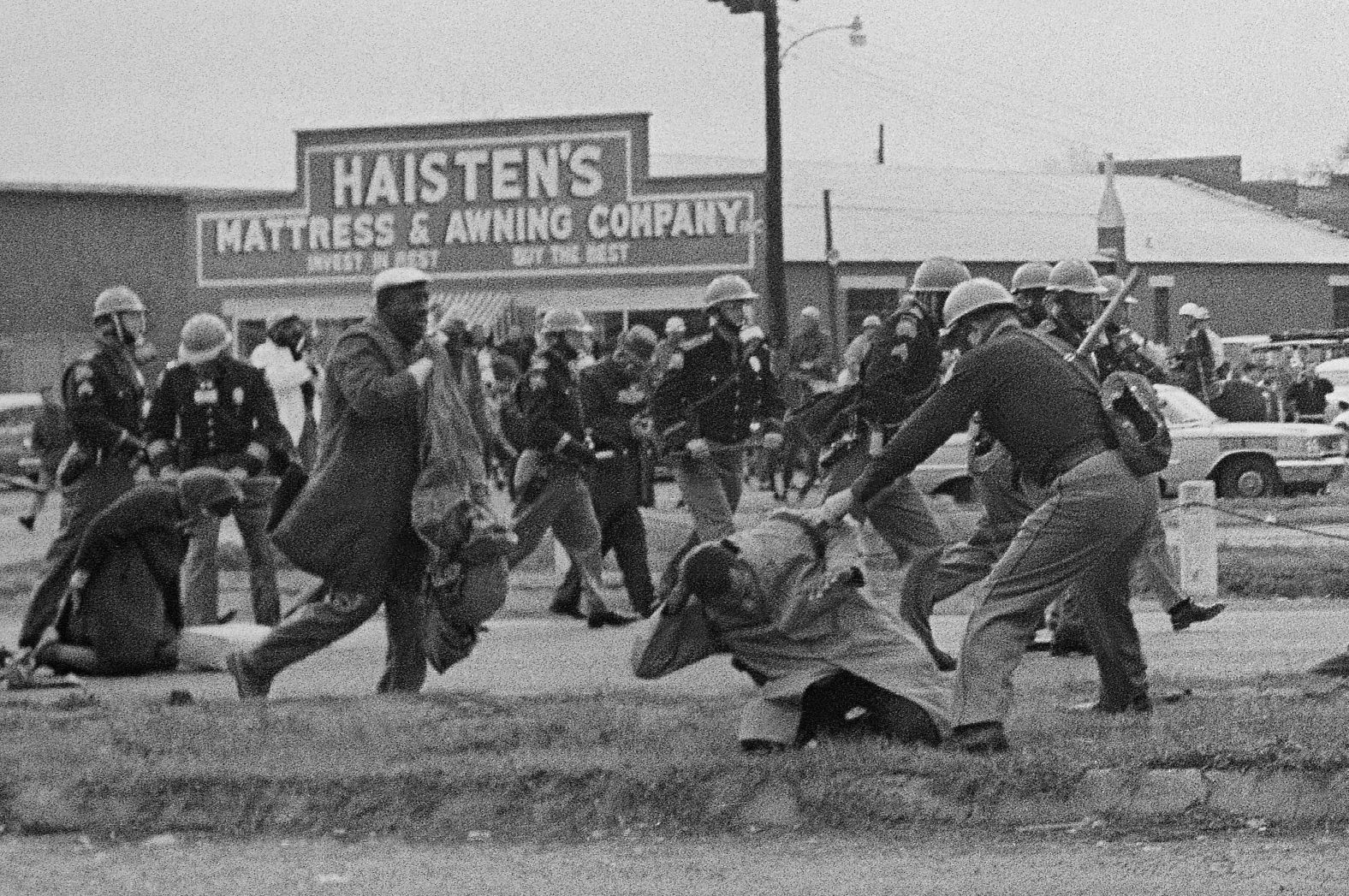 Alabama state troopers, swinging billy clubs, break up the Selma to Montgomery march on March 7, 1965. Lewis is being beaten in the foreground by a state trooper. He suffered a fractured skull. Troopers also fired tear gas, and troopers mounted on horses charged the protesters.