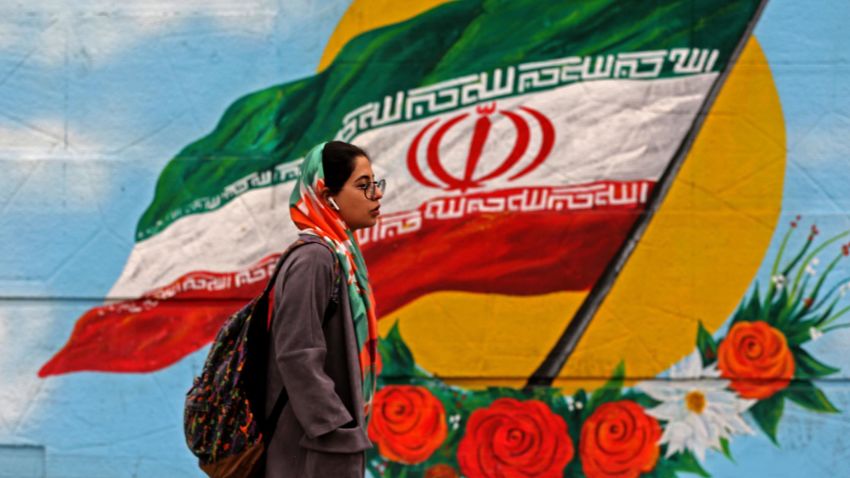 A woman walks past a mural with the Iranian national flag in Tehran, on February 20, 2020 on the eve of parliamentary election. (Photo by ATTA KENARE / AFP) (Photo by ATTA KENARE/AFP via Getty Images)