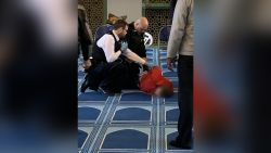 A suspect, whose face has been blurred by CNN, due to pending charges, is detained by police at London Central Mosque, following a stabbing on Thursday, February 20