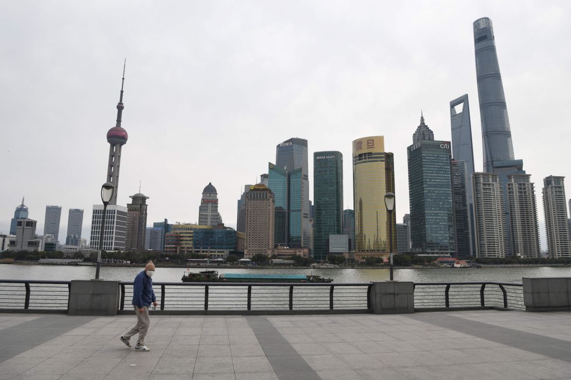 A man wearing a protective face mask walks along the usually busy Bund waterfront along the Huangpu River overlooking Shanghai's financial district on February 6.