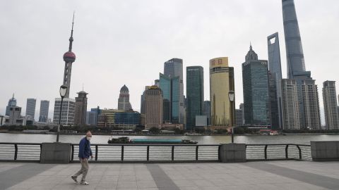 A man wearing a protective face mask walks along the usually busy Bund waterfront along the Huangpu River overlooking Shanghai's financial district on February 6.