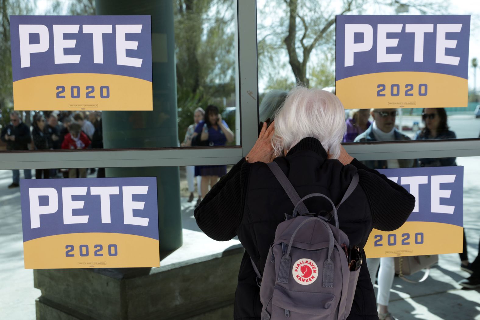 A woman in Las Vegas looks through a window as she waits in line to enter a town-hall event for Buttigieg on Tuesday.