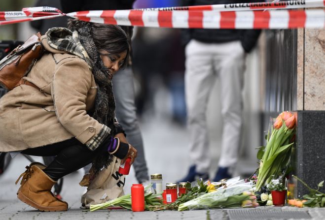 A woman puts down a candle Thursday, February 20, near the scene of <a href="https://www.cnn.com/2020/02/19/europe/hanau-germany-shootings-intl/index.html" target="_blank">a mass shooting in Hanau, Germany.</a>