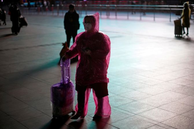 A traveler in Shanghai, China, covers herself in plastic to try to protect herself from the novel coronavirus on Monday, February 17.