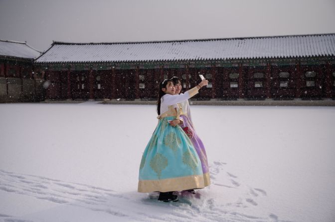People wearing traditional hanbok dress pose for selfies at the Gyeongbokgung Palace in Seoul, South Korea, on Monday, February 17.