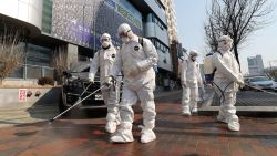 Workers wearing protective gears spray disinfectant against the new coronavirus in front of a church in Daegu, South Korea, Thursday, Feb. 20, 2020. The mayor of the South Korean city of Daegu urged its 2.5 million people on Thursday to refrain from going outside as cases of the new virus spike.
