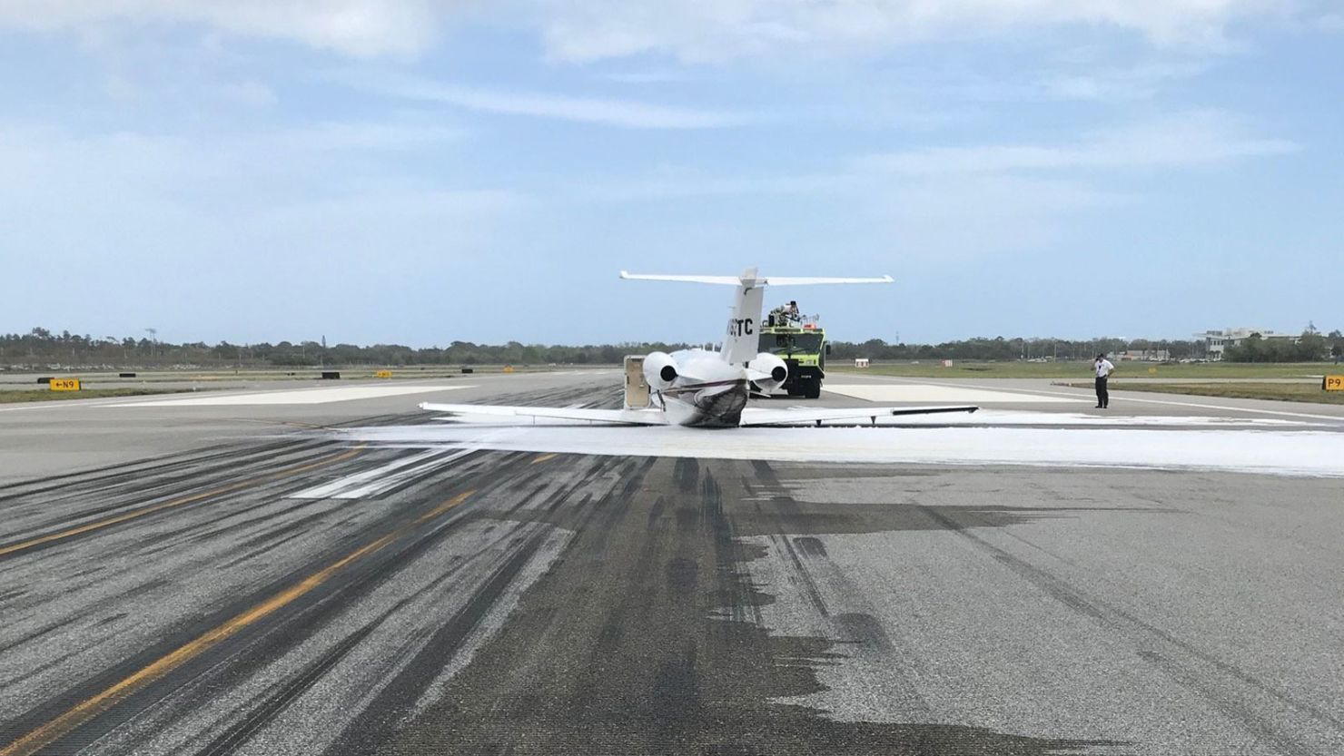 Emergency responders sprayed white foam to suppress a fire after Thursday's belly landing.