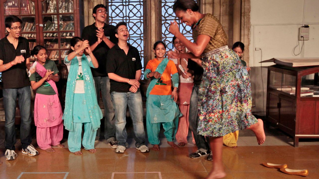 Michelle Obama dances with children at the Mumbai University in Mumbai, India.