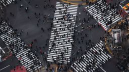 TOPSHOT - Pedestrians cross the street in Tokyo's Shibuya area on February 8, 2020.  (Photo by Charly Triballeau/AFP/Getty Images)