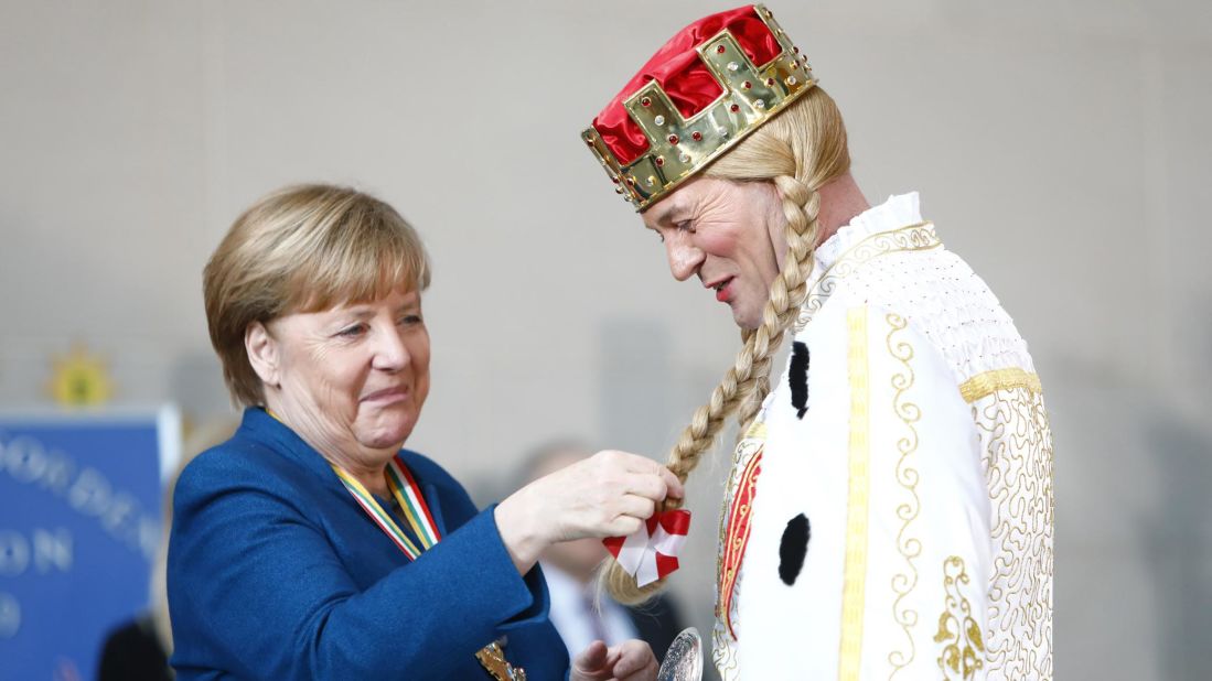 <strong>Berlin, Germany:</strong> Chancellor Angela Merkel, left, receives a member of the regional Carnivals Committee on Wednesday, January 22.