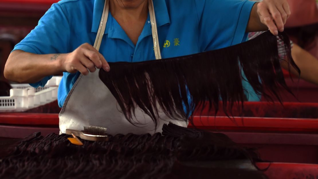 A worker assembles hair extensions at a factory in Taihe, in China's eastern Anhui province.