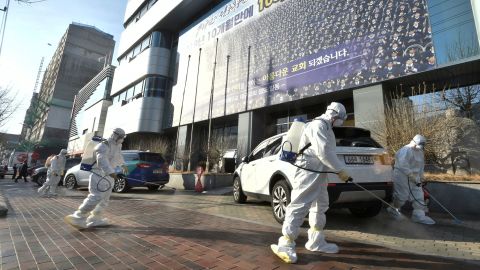 Workers from a disinfection service company sanitize a street in front of a branch of the Shincheonji religious group in Daegu, South Korea, on February 19.