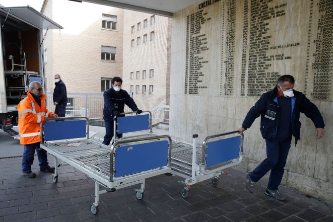 Hospital personnel in Codogno, Italy, carry new beds inside the hospital on February 21, 2020. The hospital was hosting some people who had been diagnosed with the novel coronavirus.