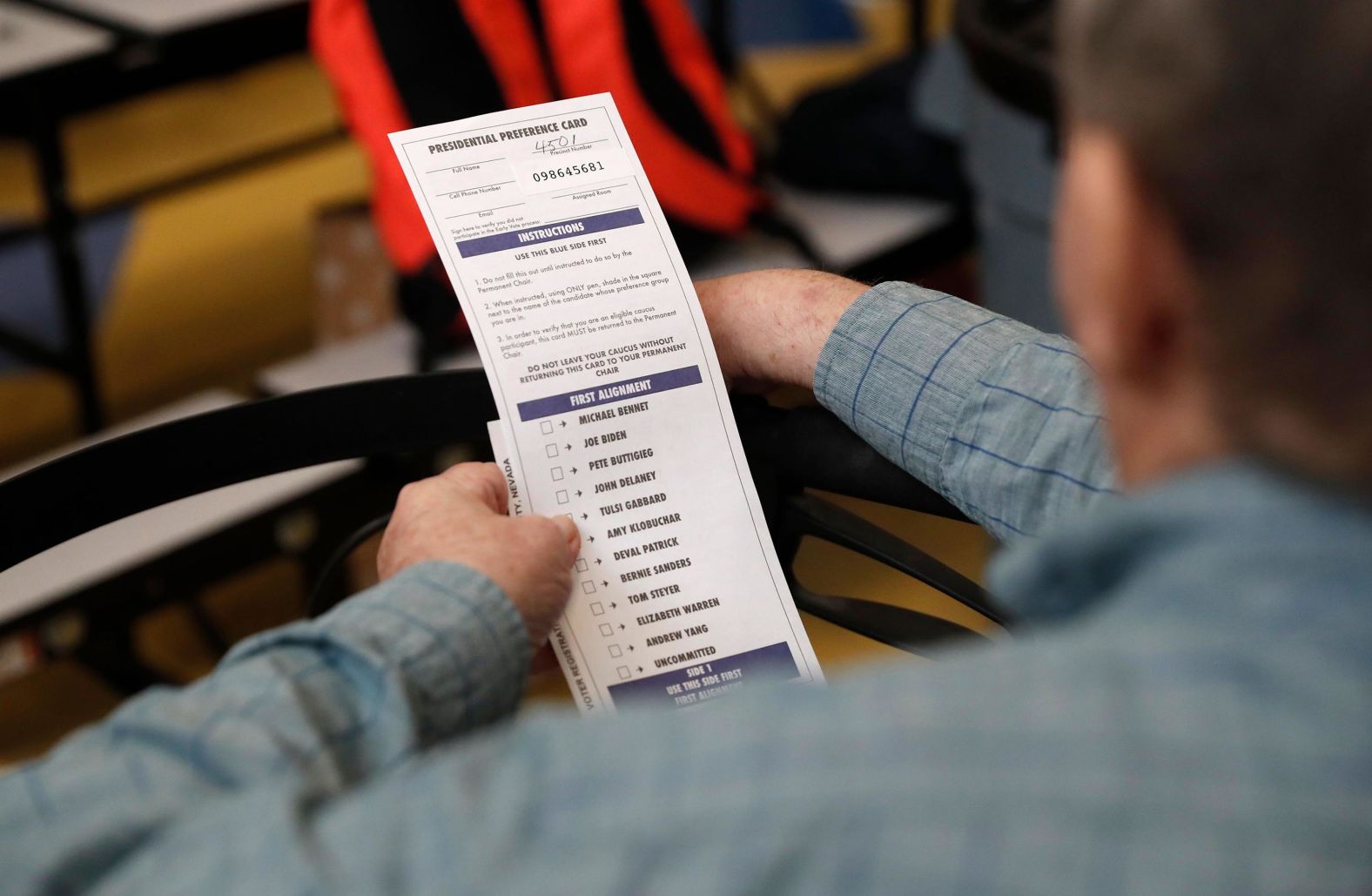 A voter looks at a presidential preference card used as a ballot.