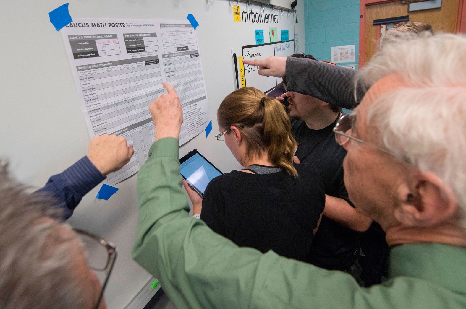 People watch a volunteer count votes during a caucus in Henderson, Nevada, on Saturday.