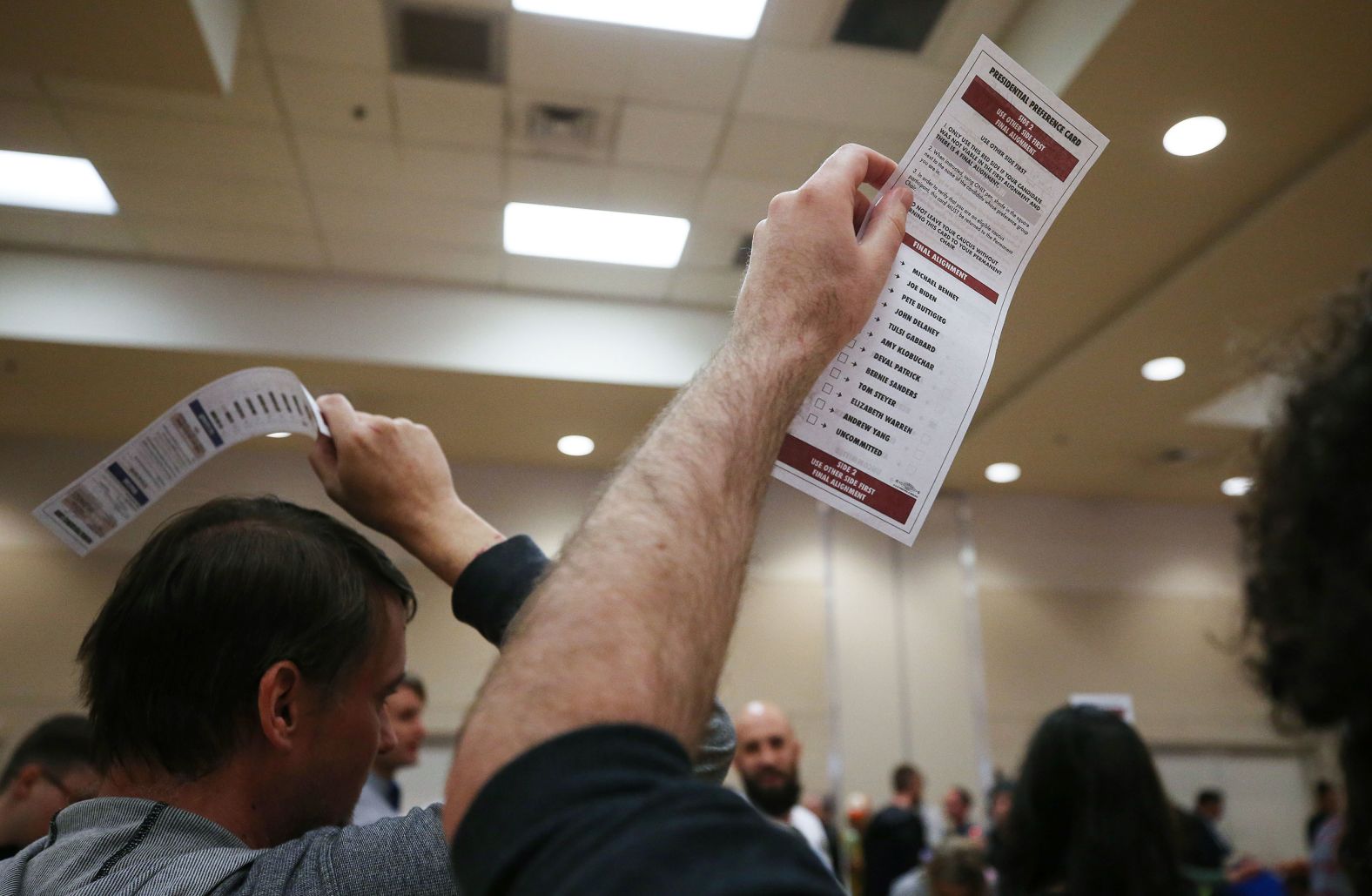 Caucusgoers hold up their presidential preference cards at a community center in Las Vegas.