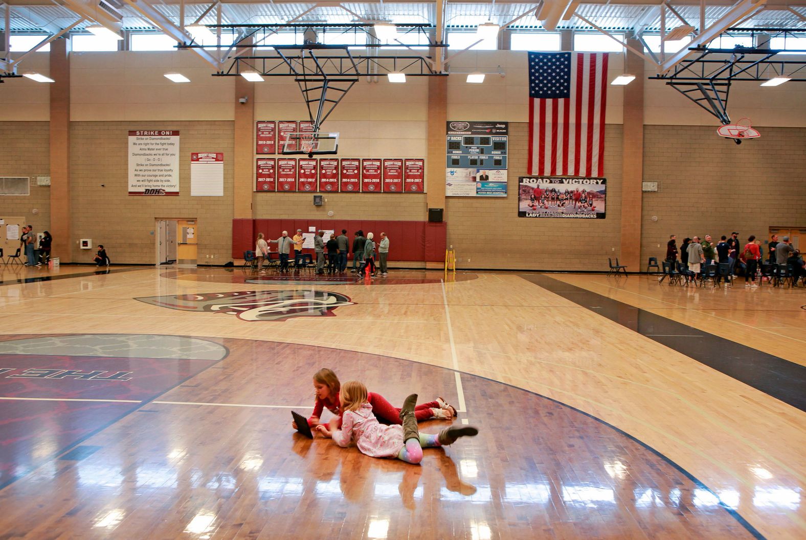 Twin sisters Emmeline and Eloise Lofthouse play in a high-school gymnasium while their mother participates in a caucus in Las Vegas.