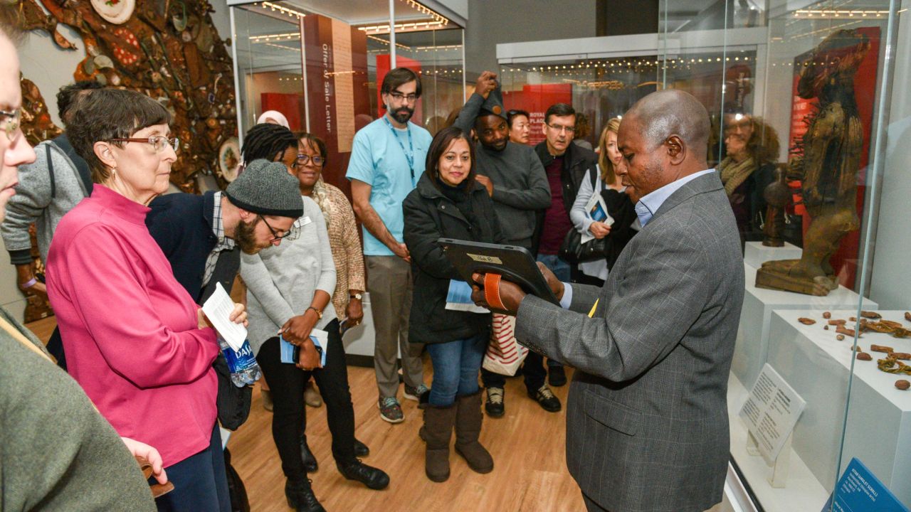 Penn Museum Global Guide Clay Katongo leading a tour of the museum's Africa gallery. Katongo is a refugee from the Democratic Republic of the Congo and Angola.